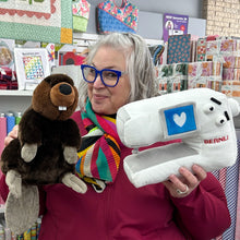 Load image into Gallery viewer, Person holding a plush beaver and a Bernina sewing machine toy in a store setting