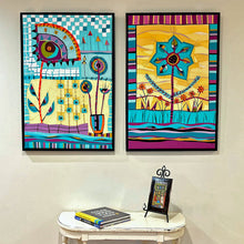Load image into Gallery viewer, Two colorful abstract artworks on a wall with a small table and books below.
