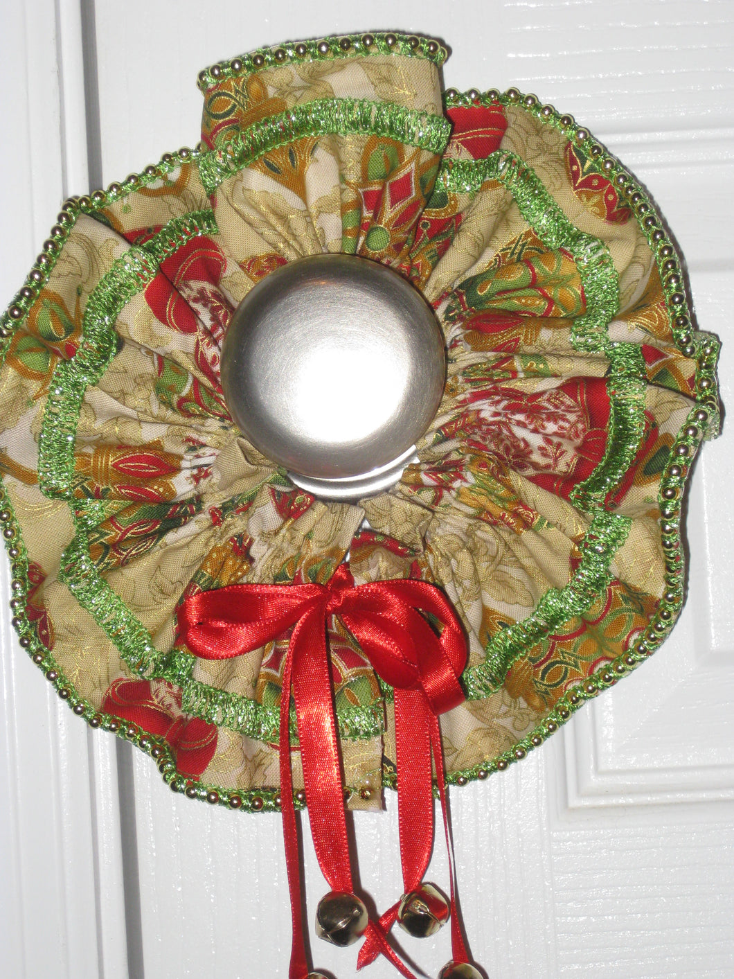 wreath made of fabric with a bell hanging from the bottom to go around a door knob.