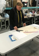 Load image into Gallery viewer, Person working at a table with tools and materials in a workshop setting
