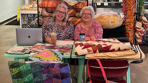 Deanna Springer and Anne Wanke with a variety of quilts 